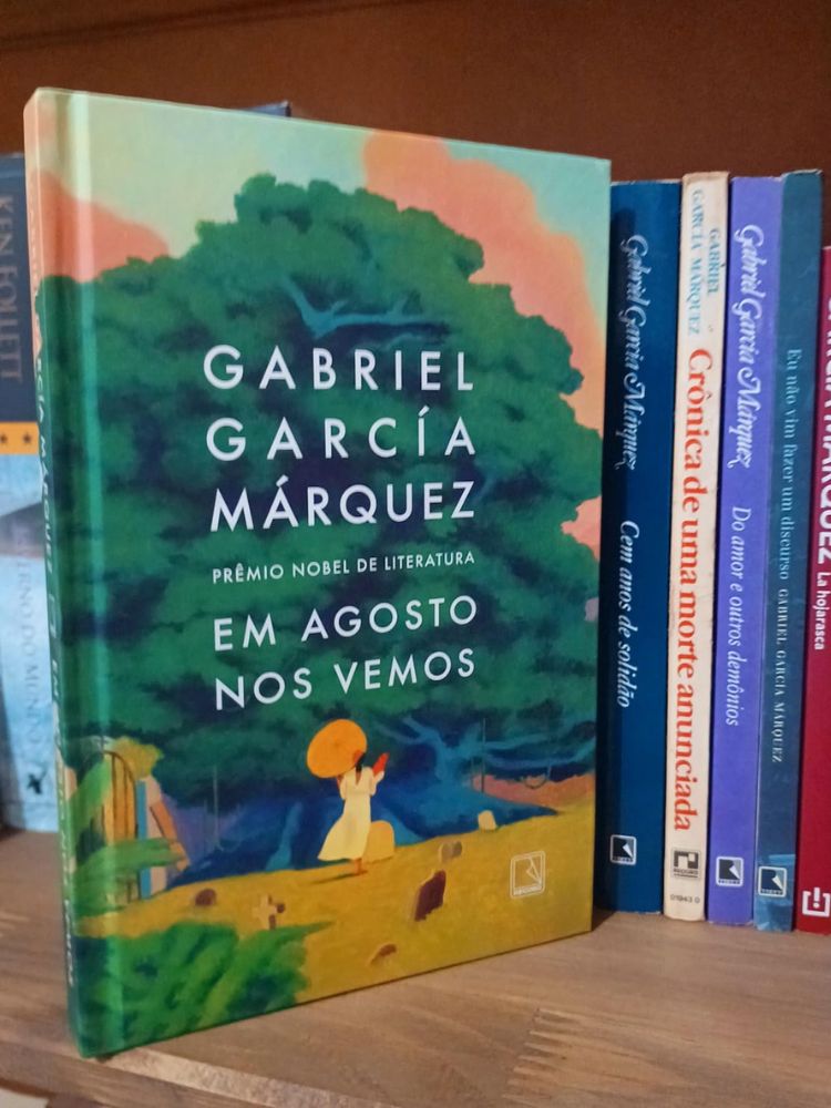 capa do livro em agosto nos vemos de gabriel garcia marquez próximo de outros livros na prateleira.